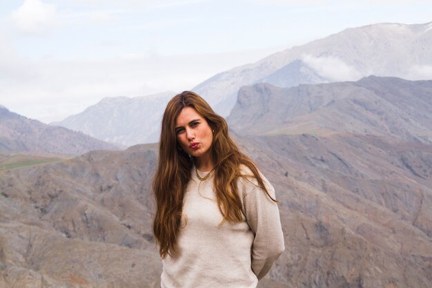 Mulher jovem, posar, frente, paisagem montanha