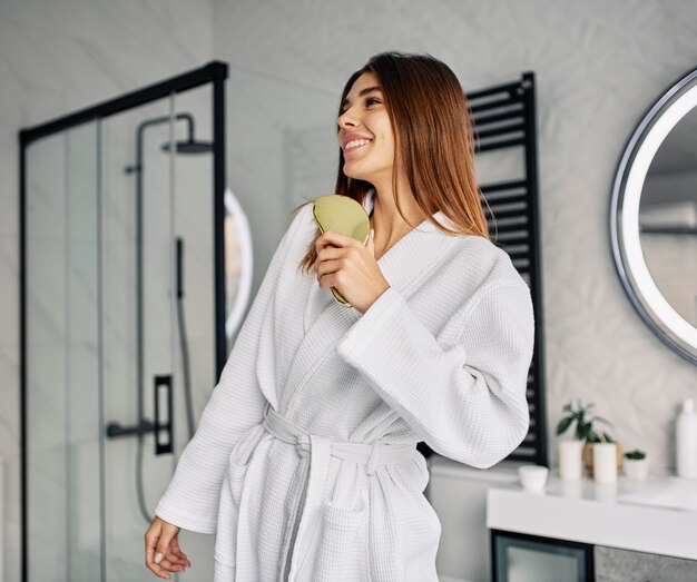Mulher jovem positiva em um roupão de banho
