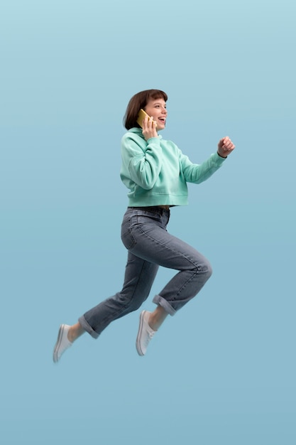 Foto grátis mulher jovem pulando isolada no azul