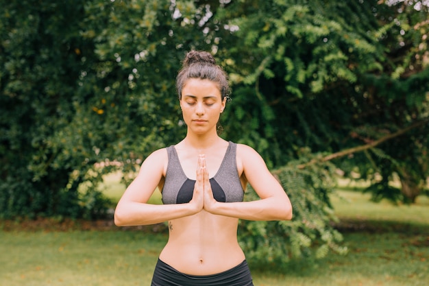 Foto grátis mulher jovem, relaxante, enquanto, meditar, e, unindo, mãos, em, mudra