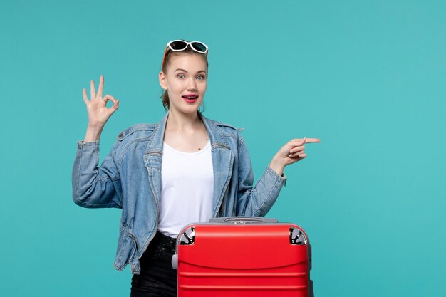 Mulher jovem se preparando para uma viagem na mesa azul