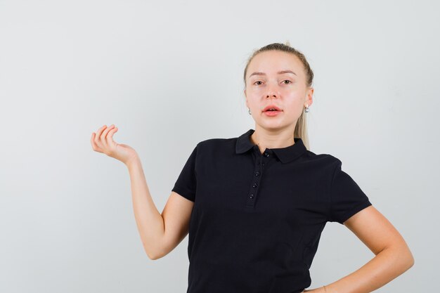 Foto grátis mulher jovem segurando a mão no quadril com uma blusa listrada e parecendo charmosa