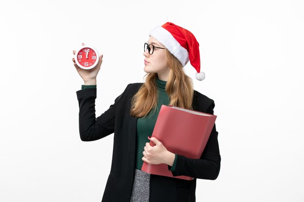 Mulher jovem segurando arquivos e relógio na parede branca do livro de Natal de ano novo