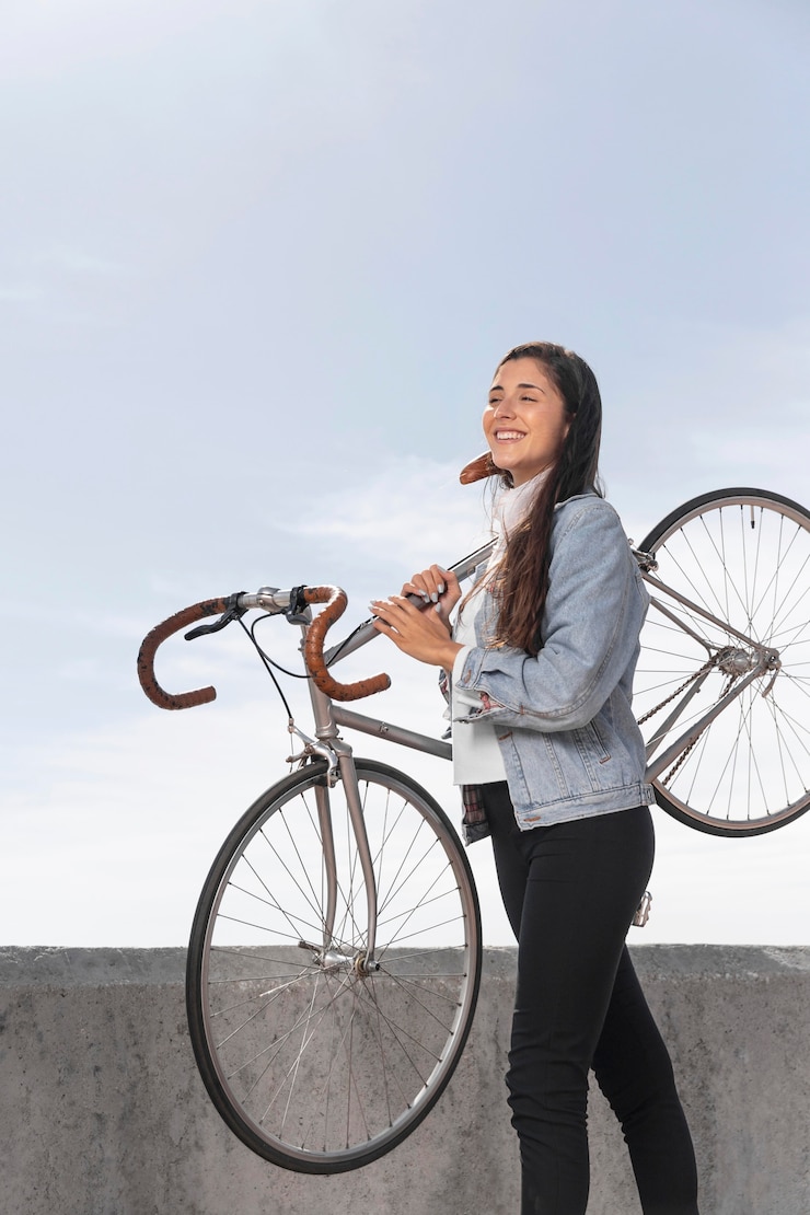 Foto grátis mulher jovem segurando sua bicicleta