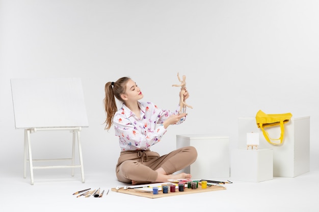 Mulher jovem segurando uma figura humana de frente para o fundo branco