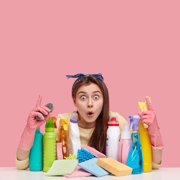 Foto grátis mulher jovem sentada ao lado de produtos de limpeza