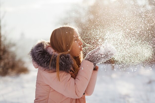 Mulher jovem, soprando, neve, de, mãos