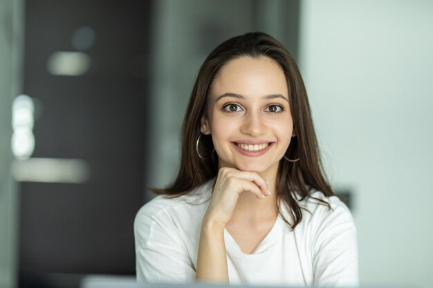 Mulher jovem sorridente digitando em seu laptop