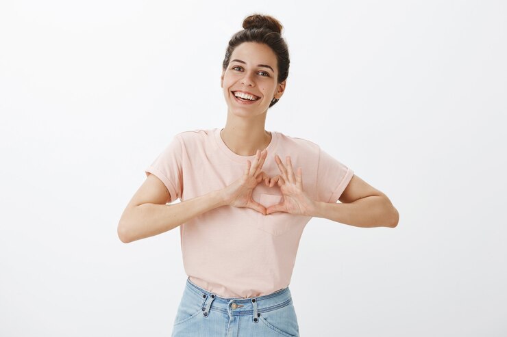 Foto grátis mulher jovem sorridente e elegante posando contra a parede branca