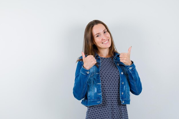 Mulher jovem sorridente mostrando um bom gesto de mãos no fundo branco