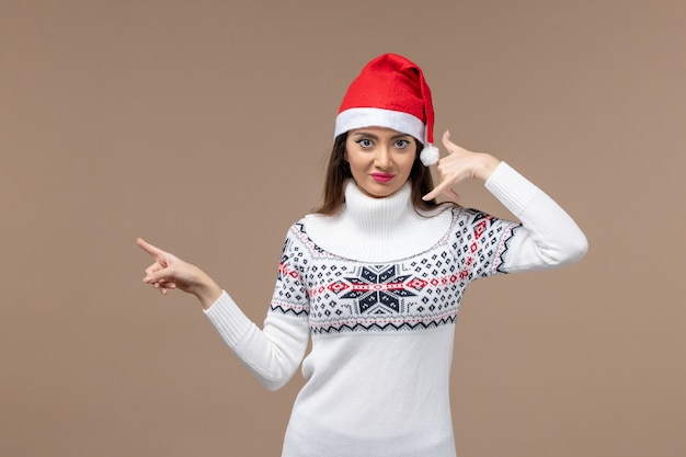 Mulher jovem sorrindo e posando em fundo marrom emoção de férias de natal