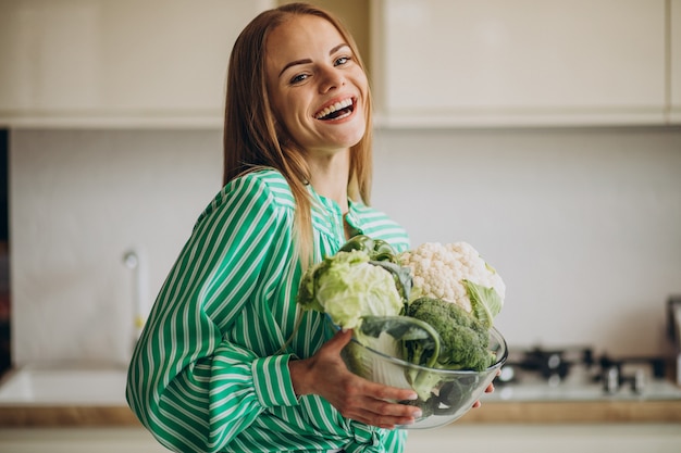 Foto grátis mulher jovem sorrindo e segurando couve-flor