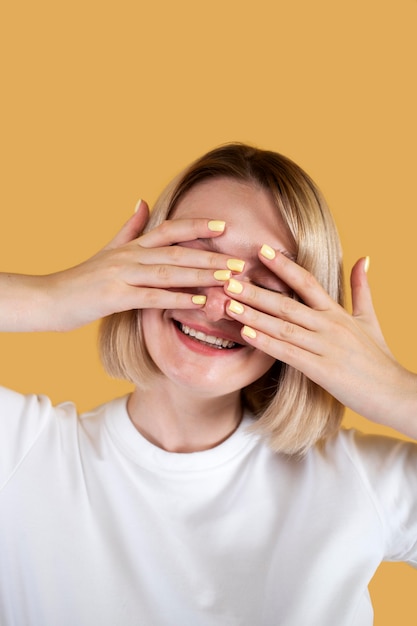 Mulher jovem sorrindo isolada em amarelo