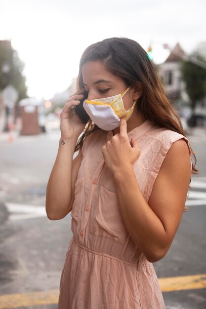 Foto grátis mulher jovem tolerando a onda de calor enquanto usa uma máscara médica