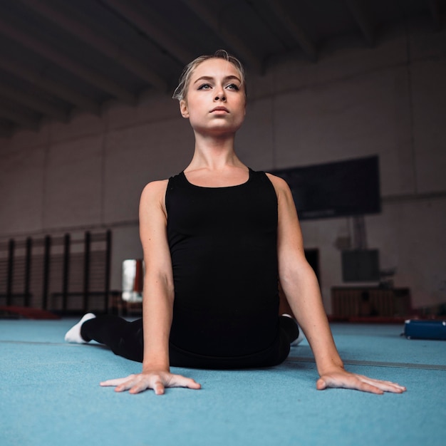 Foto grátis mulher jovem treinando para as olimpíadas de ginástica