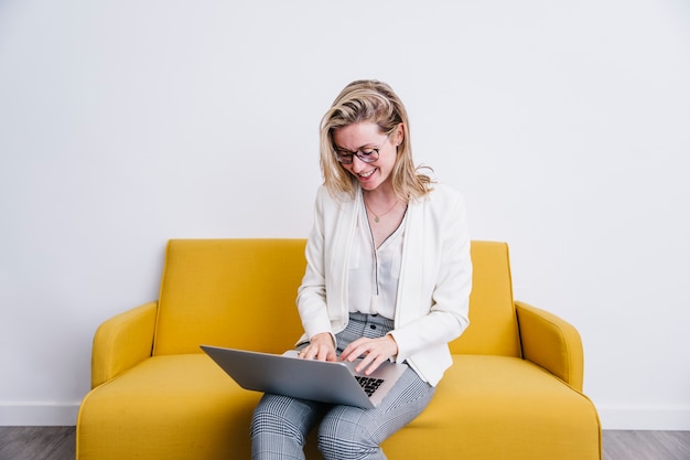 Mulher jovem, usando computador portátil, ligado, sofá