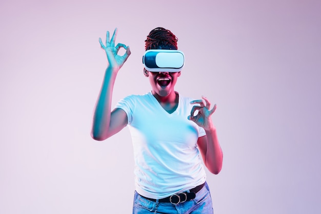 Mulher jovem usando óculos VR com luzes de néon