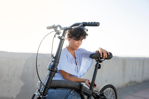 Mulher jovem usando sua bicicleta dobrável