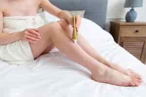 Foto grátis mulher jovem usando um creme para as pernas