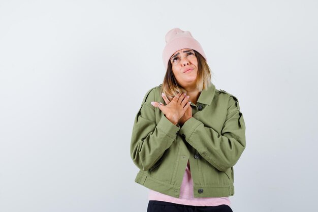 Mulher jovem vestindo uma jaqueta e um chapéu rosa