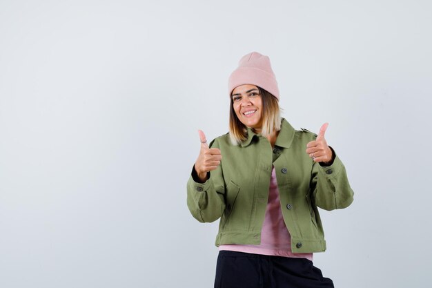 Mulher jovem vestindo uma jaqueta mostrando os polegares para cima
