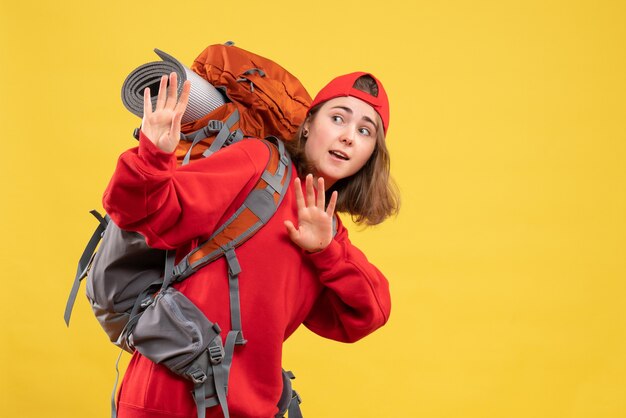 Mulher jovem viajante com mochila vermelha tentando parar algo