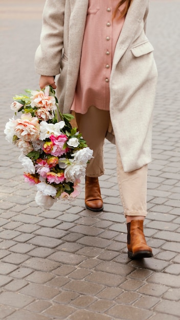 Foto grátis mulher lá fora segurando um buquê de flores na primavera