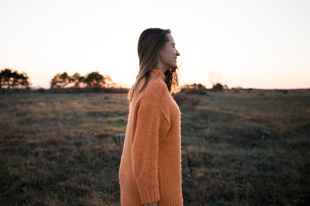 Foto grátis mulher lateral de pé em um campo