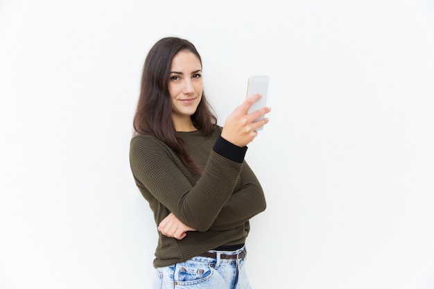 Mulher latina positiva amigável, segurando o celular