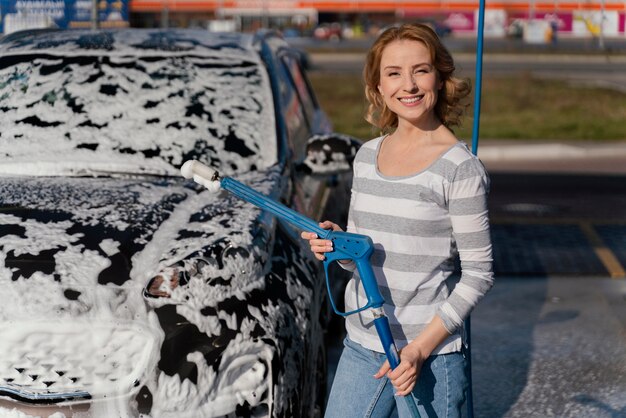 Mulher lavando carro lá fora