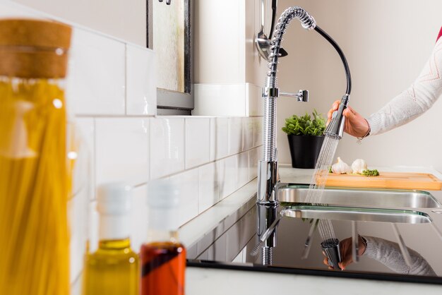 Mulher lavando pratos na cozinha