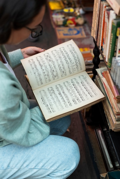 Mulher lendo livro no mercado de segunda mão