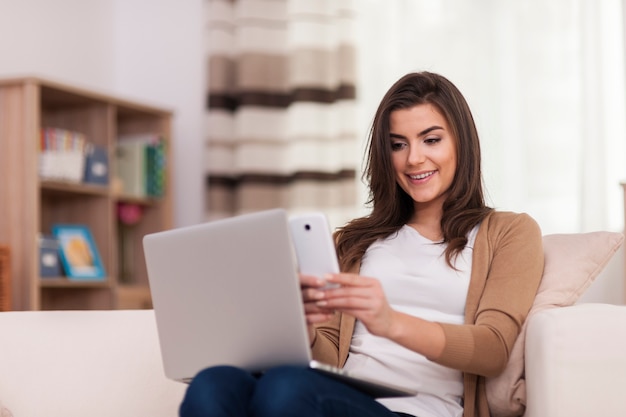 Mulher lendo o código qr pelo celular em casa