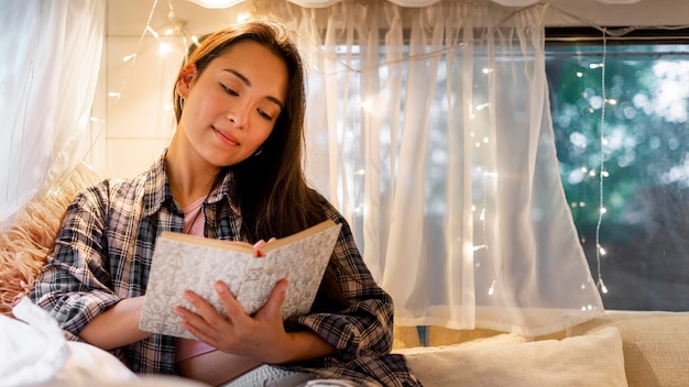 Mulher lendo um livro dentro de casa