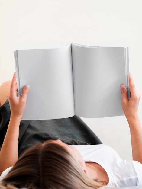 Foto grátis mulher lendo uma revista de maquete