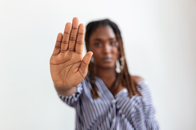 Mulher levantou a mão para dissuadir a campanha pare a violência contra as mulheres Mulher afro-americana levantou a mão para dissuadir com espaço de cópia