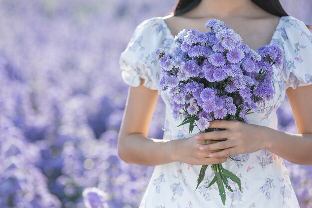 Mulher linda apreciando o campo de flores