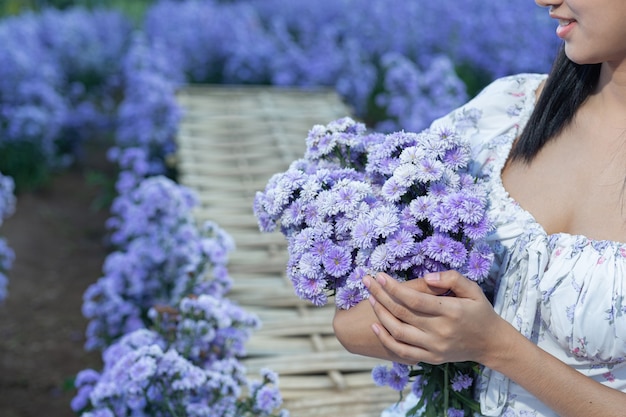 Mulher linda apreciando o campo de flores