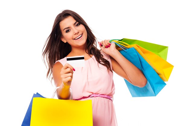 Mulher linda com sacola de compras multicolorida e cartão de crédito