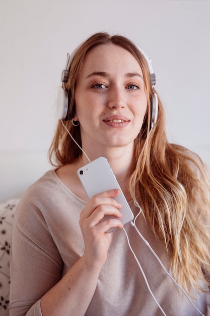 Mulher linda com smartphone e fones de ouvido