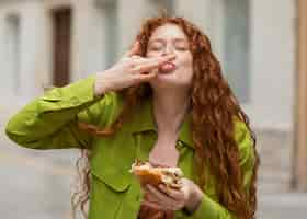 Foto grátis mulher linda comendo comida de rua deliciosa ao ar livre