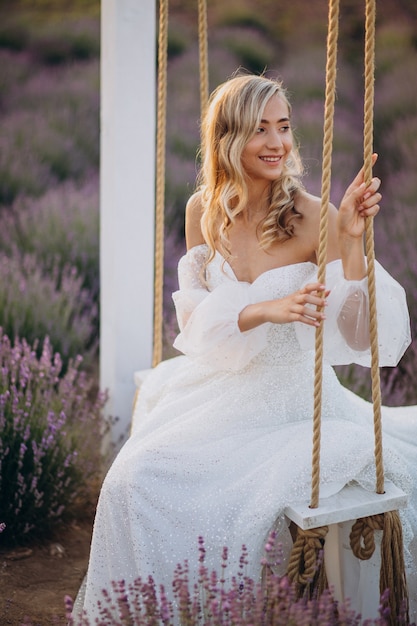 Mulher linda em vestido de noiva em campo de lavanda