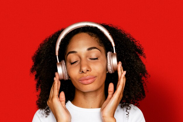 Mulher linda ouvindo música com fones de ouvido no aparelho digital