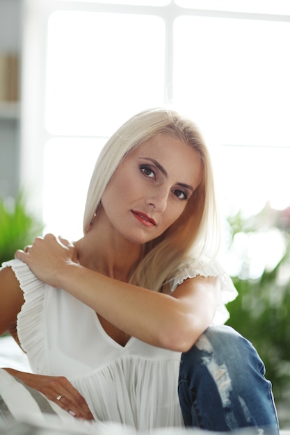 Mulher linda relaxando no sofá em casa