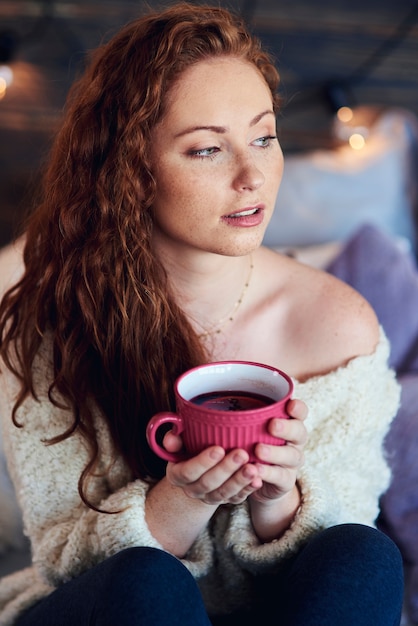 Mulher linda tomando chá quente em dia de inverno