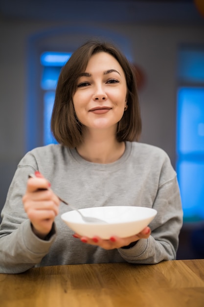 Foto grátis mulher linda tomando seu café da manhã em sua cozinha