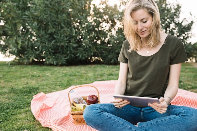 Foto grátis mulher linda usando tablet perto de frutas