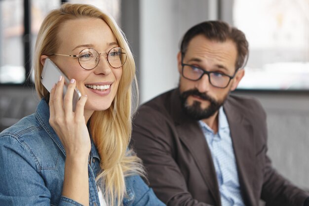 Mulher loira alegre e atraente fazendo telefonema