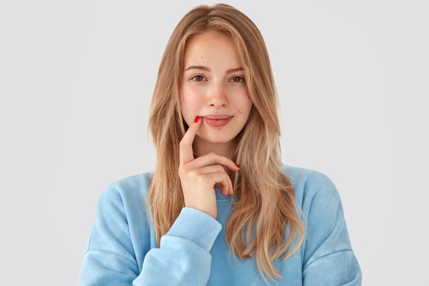 Mulher loira com camisa azul posando