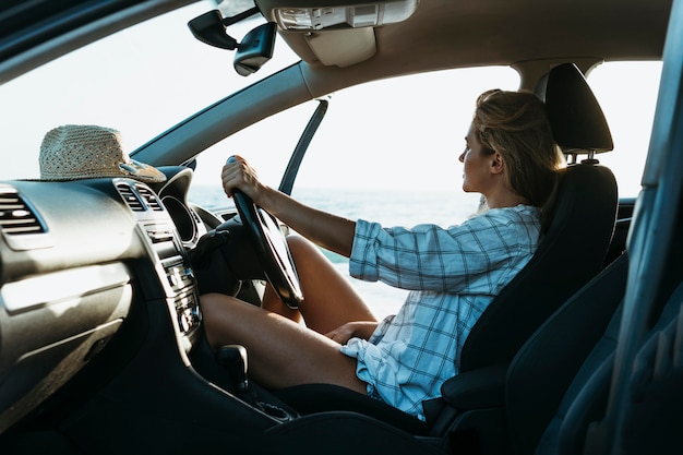 Mulher loira com meia dose no banco do motorista